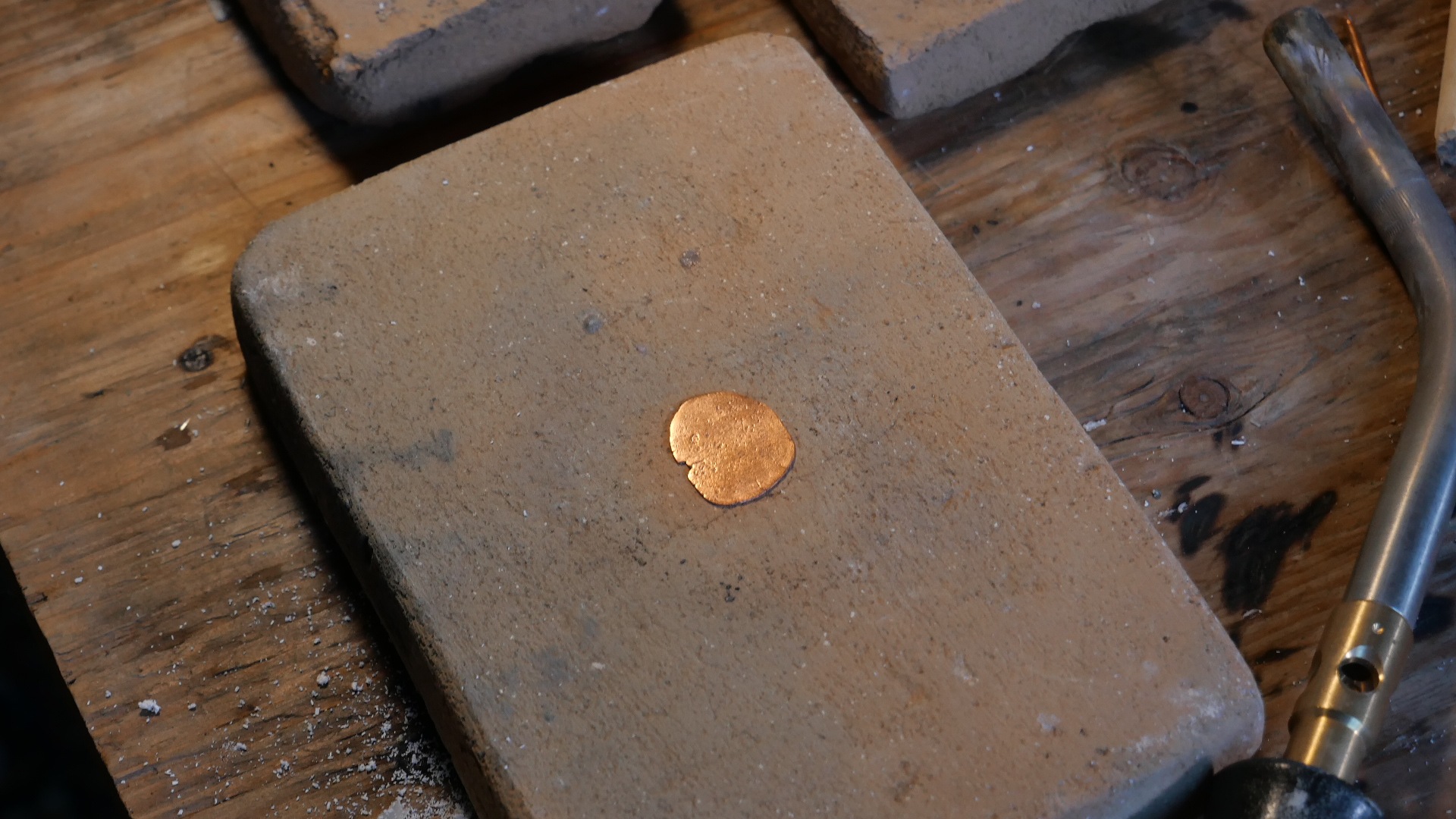 Bouton de cuivre extrait du minerai d'Eustis, fondu sur brique réfractaire