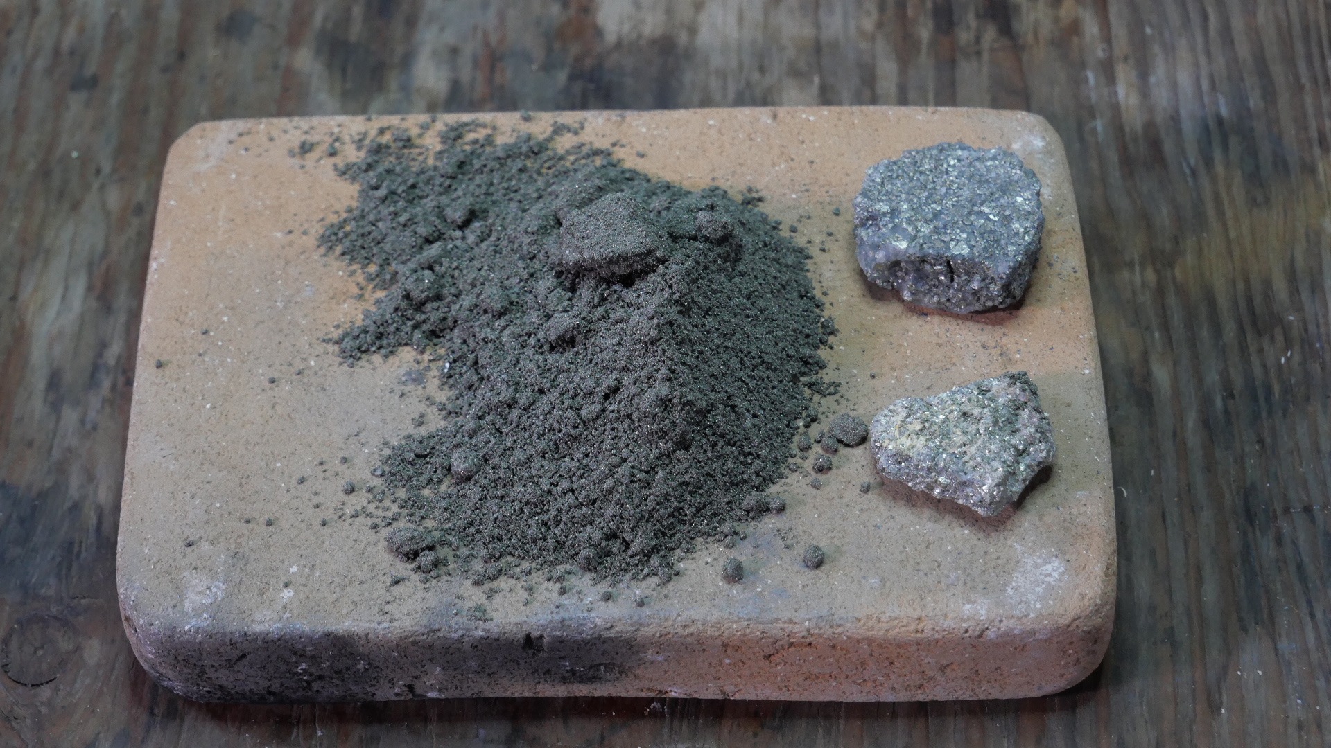 Minerai d'Eustis collecté en 1986 : fragments de chalcopyrite et minerai broyé sur brique réfractaire
